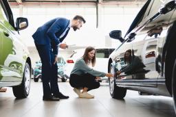 Best time to buy a car with woman looking at vehicle.